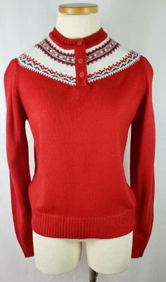 a red sweater on a mannequin with white and blue trim around the collar