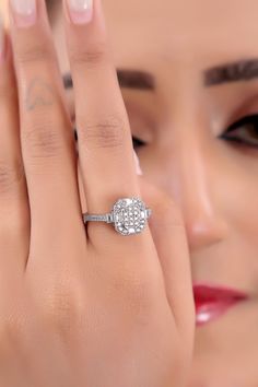 a close up of a person's hand with a diamond ring on her finger