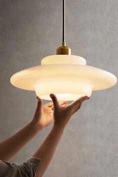 a person reaching up to a light fixture