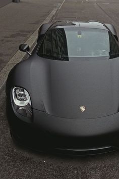 a black sports car is parked on the street