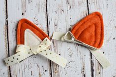 an orange and white bow tie on top of a wooden table next to a pair of scissors