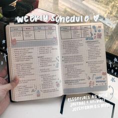 an open notebook with writing on it and the words weekly schedule written in japanese, sitting next to a window