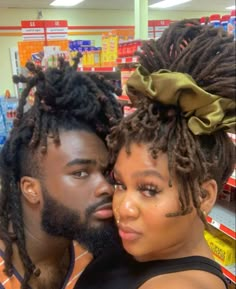 a man and woman with dreadlocks are posing for the camera in a store