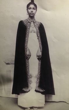 an old black and white photo of a woman wearing a dress with beading on it