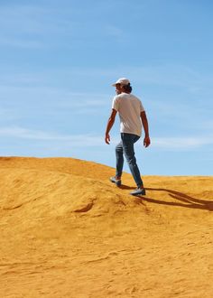 a man standing on top of a sandy hill