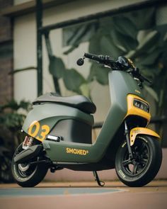 a green and yellow scooter parked in front of a building