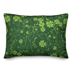 a green pillow with four leaf clovers on the front and back, all over it