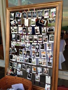 a wooden frame filled with pictures and photos on the wall next to a wicker basket