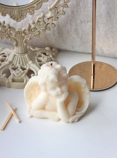 there is a small figurine on the table next to some matches and a mirror