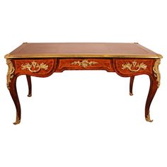 an antique desk with two drawers on one side and gold trimmings on the other