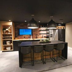 a kitchen with an island and bar stools in front of the countertop area