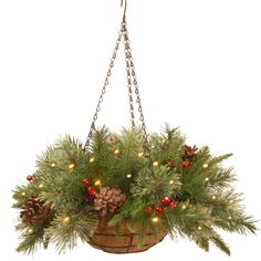 a hanging basket filled with pine cones and evergreen needles, decorated with red berries and lights