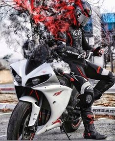 a man sitting on top of a motorcycle with red flames coming out of the back