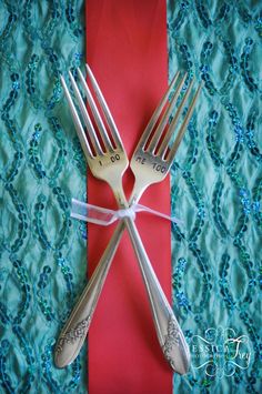 two forks are tied to a red and blue table cloth with the word love written on it