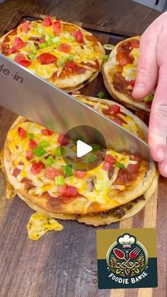 someone is cutting up some pizzas with a knife