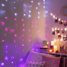 a room with purple lights and pictures on the wall, along with a bed covered in pillows