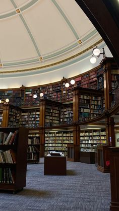 the inside of a library with many bookshelves and lights hanging from the ceiling