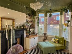 a living room filled with furniture and a fire place next to a window covered in lights