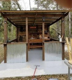 an outdoor bbq with grills and chairs around it