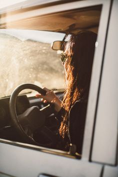 a woman sitting in the driver's seat of a car