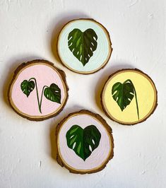 four pieces of wood with leaves painted on them are arranged in the shape of hearts