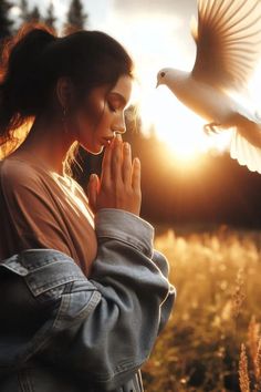 a woman standing in a field with a bird flying over her head and the sun behind her