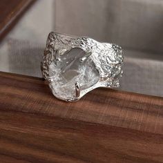 a silver ring sitting on top of a wooden table