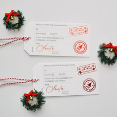 two red and green christmas wreaths are next to some white boarding cards with twine