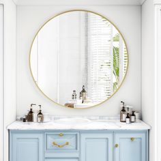 a bathroom with blue cabinets and a round mirror