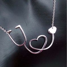 a silver necklace with two hearts and a stethoscope