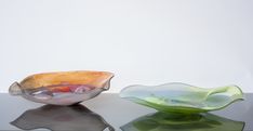 two glass bowls sitting on top of a table