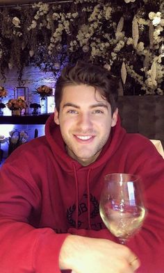 a man sitting at a table with a glass of wine