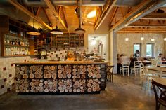 the interior of a restaurant with wood slices on the counter and people sitting at tables