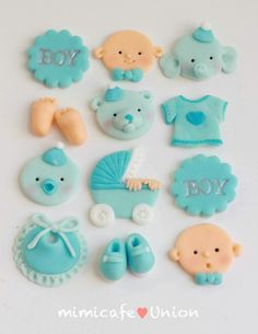 baby boy cookies are arranged on a white surface with the words boy spelled in blue