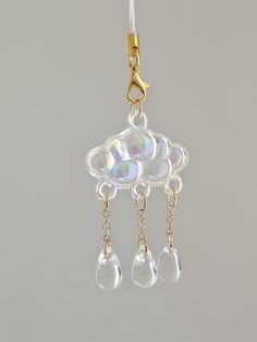 a pair of earrings hanging from a gold plated earring with clear glass beads