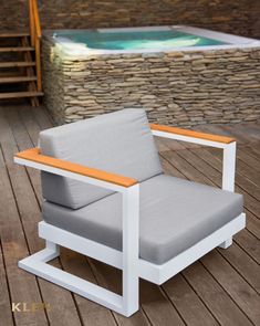 a white chair sitting on top of a wooden floor next to a hot tub filled with water