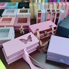 there are many different boxes on the table with one open and one closed, all in pastel colors