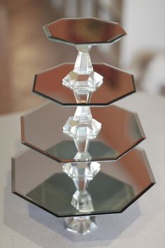 three glass hexagonal pieces on top of a white table with a mirror in the background