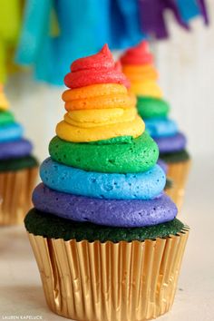 cupcakes with rainbow frosting and decorations on top