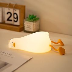 a white light sitting on top of a table next to a book and calendars