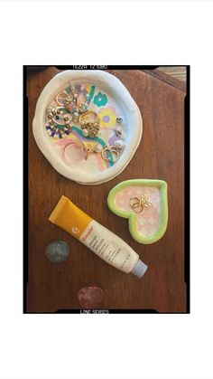 a wooden table topped with lots of items like a plate and toothpaste on top of it