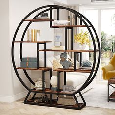 a living room filled with furniture and a large circular book shelf next to a window