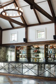 an empty bar with lots of bottles on the shelves and lights hanging from the ceiling