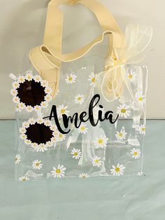 a clear bag with white daisies on it and the word amelie written in black