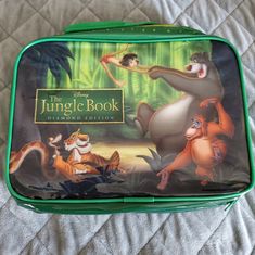 the jungle book lunch box is sitting on a bed with an image of disney characters