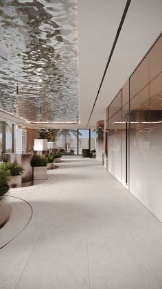 an empty hallway with potted plants on either side and large windows in the background