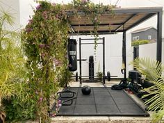 a home gym is shown in the middle of some plants and flowers on the ground