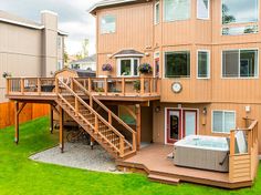 a hot tub sitting on top of a wooden deck next to a large brown building