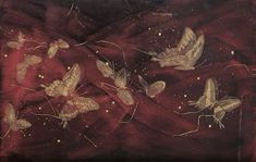 a group of butterflies flying across a red cloth covered in gold flecks and stars