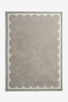 a rug with scalloped edges and the words rusty ducy on it in grey